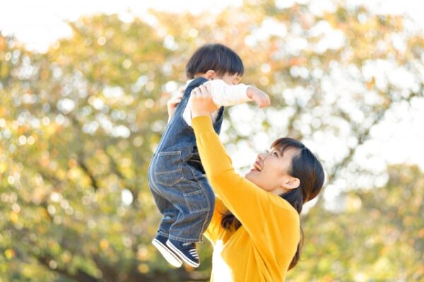 子どもを抱き上げるママ