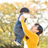 子どもを抱き上げるママ